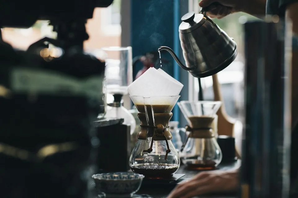 Pour-over coffee being prepared in a sunlit café